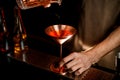 Close-up metal martini glass in which bartender pours cocktail. Royalty Free Stock Photo