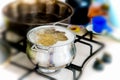 Metal pot with pasta and boiling water on the kitchen burner Royalty Free Stock Photo