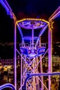 Close up of the metal structure of the wheel of fortune with a combination of purple blue en yellow lights