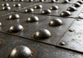 A close-up of a metal surface with large, rounded rivets arranged in Royalty Free Stock Photo