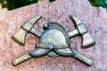 Close up of metal symbol of firefighters on a stone slab