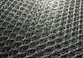 Close-up of a metal wire mesh, featuring a diamond-shaped pattern Royalty Free Stock Photo