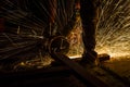 Close up of metal worker using angle grinder to cut metal bar