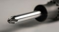 Close-up of a Metallic Screwdriver Tip in Sharp Focus on Gray Background Royalty Free Stock Photo