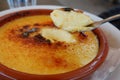 Close up on metallic spoon plunged into plate with Catalan cream in French cafeteria in France