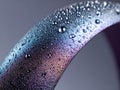 Close-up of a metallic surface with water droplets and colorful reflections Royalty Free Stock Photo