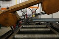A close-up of a metalworking machine in operation, cutting through metal with precision, surrounded by metal shavings