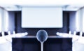 Close up microphone center of picture with screen projector background in meeting