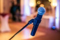 Close up of microphone in concert or conference hall with blurred lights at background Royalty Free Stock Photo