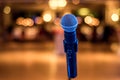 Close up of microphone in concert or conference hall with blurred lights at background Royalty Free Stock Photo