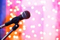 Close up of microphone in concert hall with blurred lights at background Royalty Free Stock Photo