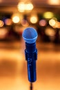 Close up of microphone in concert or conference hall with blurred lights at background Royalty Free Stock Photo