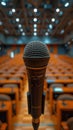 CloseUp of Microphone in an Empty Auditorium with Blurred Background of Rows of Seats and Ceiling Lights Royalty Free Stock Photo