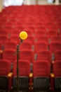 Close up of microphone in front of empty chairs hall. Before a conference, concert, seminar. Royalty Free Stock Photo
