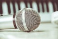 Close up on a microphone during recording session with a singer, piano in the background, music studio. Royalty Free Stock Photo