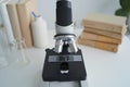 Close-up of microscope in the foreground on a clean lab bench with glassware. Royalty Free Stock Photo
