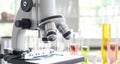 Close up of microscope in laboratory with  blurred background of glass test tube stack Royalty Free Stock Photo