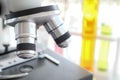 Close up of microscope in laboratory with  blurred background of glass test tube stack Royalty Free Stock Photo