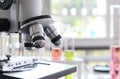 Close up of microscope in laboratory with  blurred background of glass test tube stack. Scientist, laboratory, research, pharmaceu Royalty Free Stock Photo