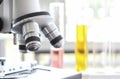 Close up of microscope in laboratory with  blurred background of glass test tube stack Royalty Free Stock Photo