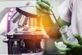 Close up microscope with student biotechnology girl using forceps for small pieces plant tissue Royalty Free Stock Photo