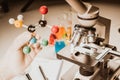 Close up of microscope viewing sample with atom ball and stick molecular model for research, learn. Royalty Free Stock Photo