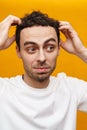 Close up of a mid aged brunette man examining his hair Royalty Free Stock Photo