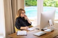 Attractive mid aged woman sitting at home and using compter for work Royalty Free Stock Photo