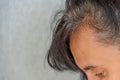 Close up of middle age caucasian woman with dark brown hair and regrown gray hair roots