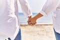 Close up of middle age hispanic couple of husband and wife together holding hands by the beach on a sunny day Royalty Free Stock Photo