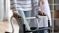 Close up middle aged woman holding hands on walking frame. Royalty Free Stock Photo