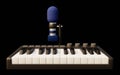 Close-up of a midi controller keyboard and a desktop microphone from a home music studio Royalty Free Stock Photo