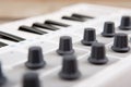 Close up of MIDI controller volume fader, knob and keys