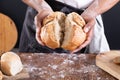 Close-up midsection of african american male baker breaking baked bread over table