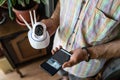 Close up on midsection of unknown man holding home security surveillance camera and mobile phone trying to install an app top view Royalty Free Stock Photo