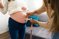 Doula checking the growth of a pregnant woman`s belly Royalty Free Stock Photo