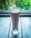 Close-up of a milkshake in a high glass goblet against a window Royalty Free Stock Photo