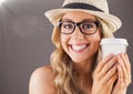Close up of millennial woman smiling with coffee and flare against brown background Royalty Free Stock Photo