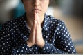 Close up mindful Indian woman putting hands in prayer