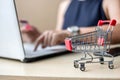 Close up mini cart, Asian businesswoman holding credit card and using laptop for online shopping while making orders. internet, Royalty Free Stock Photo