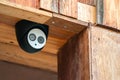 Close up mini CCTV camera black case is set up on the wood ceiling building Royalty Free Stock Photo