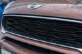 Close Up of mini cooper logo with raindrops and front grille car mini cooper on braun car parked in street Royalty Free Stock Photo
