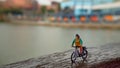 Close up Mini Figure Woman toys bicycling at River Side Path Way with negative or copy space for text area placement