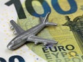 close up of miniatur airplane on 100 euro banknote, rising prices for flights or travel cost concept Royalty Free Stock Photo