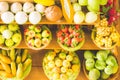 Close up Miniature clay figurine Thailand`s floating market,Miniature boat carrying tropical fruit on wood background. Royalty Free Stock Photo