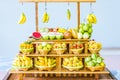 close up Miniature clay figurine Thailand`s floating market,Miniature boat carrying tropical fruit on wood background. Royalty Free Stock Photo