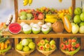 Close up Miniature clay figurine Thailand`s floating market,Miniature boat carrying tropical fruit on wood background. Royalty Free Stock Photo