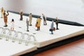 close up of miniature people with social network diagram on open Royalty Free Stock Photo
