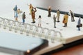 close up of miniature people with social network diagram on open Royalty Free Stock Photo