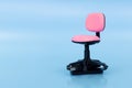 Close-up of a miniature pink office chair with a USB flash drive inserted into its base on a solid blue background Royalty Free Stock Photo